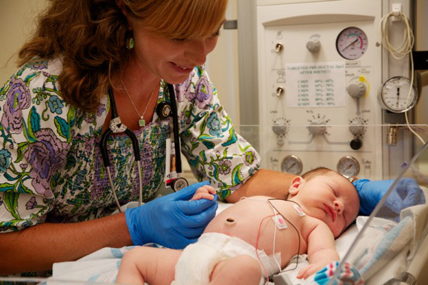 Mother holding newborn baby in hospital room